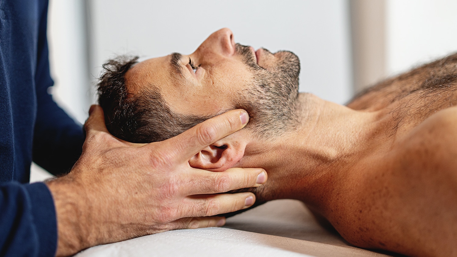Chiropractor performing hands-on neck adjustment to relieve pain