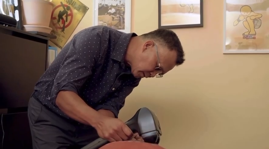 Dr. Rabbonni Tacusalme using percussion therapy device for back pain treatment